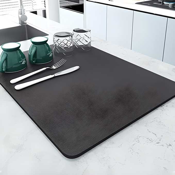 Quick-drying mat displayed on a kitchen countertop with dishes and cutlery, showcasing its sleek design and functionality.