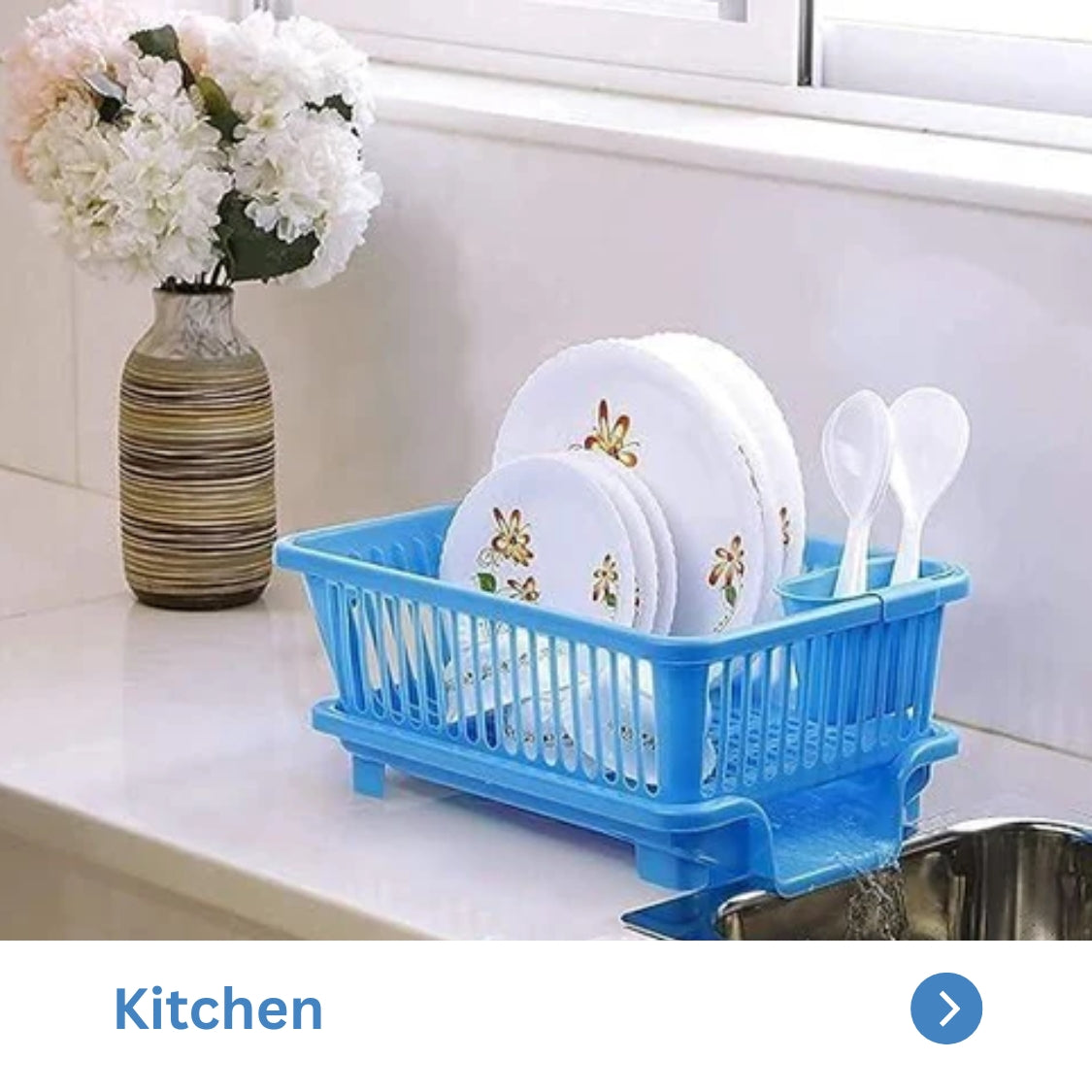 Blue dish rack with plates and spoons on a kitchen counter, complemented by a flower vase.